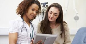 Healthcare professional providing diabetes counselling and patient education using a tablet.